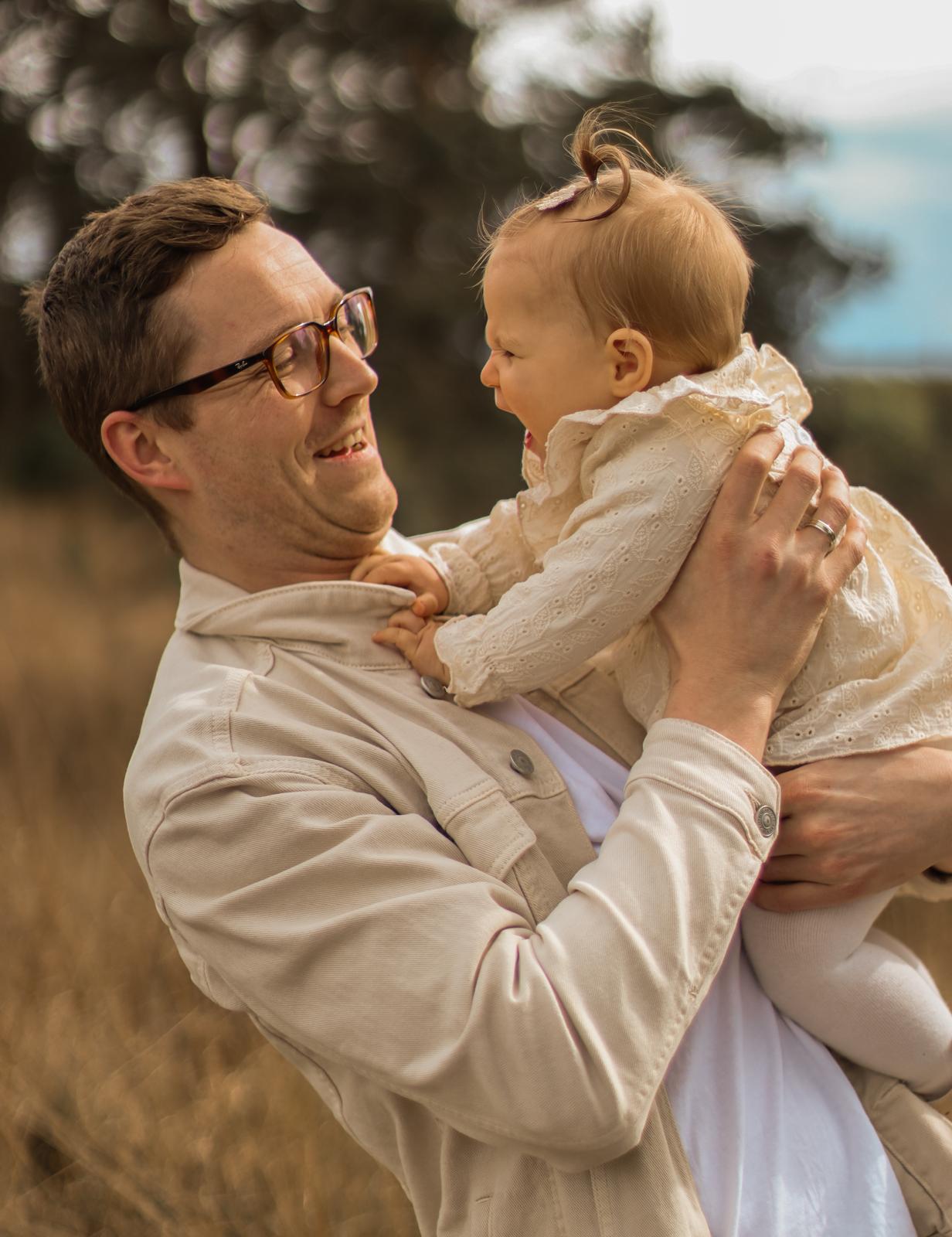 Familie fotografie Haaksbergen - vader met lachende baby in gouden veld door Kim Scharenborg Fotografie