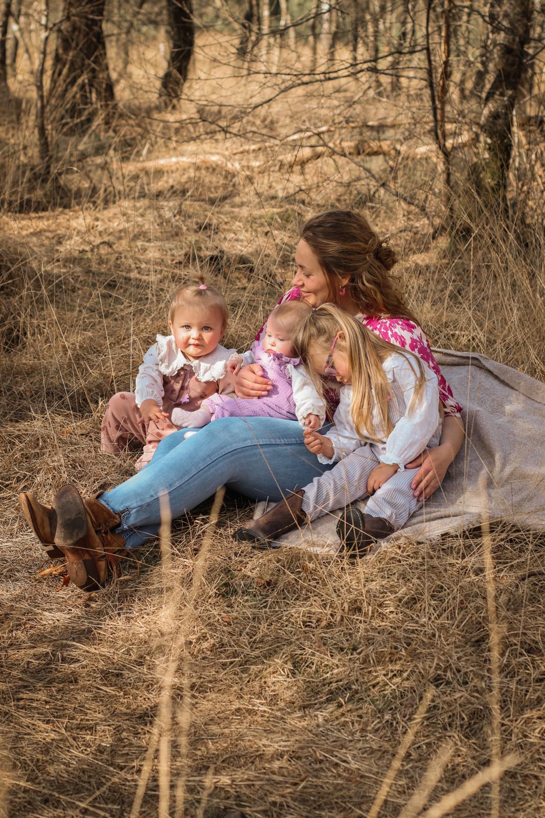 Familie fotografie Haaksbergen - moeder met drie kinderen in droog gras door Kim Scharenborg Fotografie