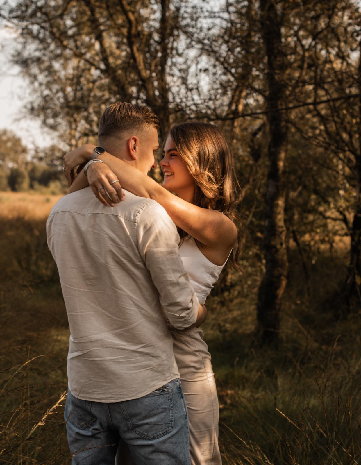 Koppel fotografie Haaksbergen - jong stel omhelst elkaar in gouden veld door Kim Scharenborg Fotografie