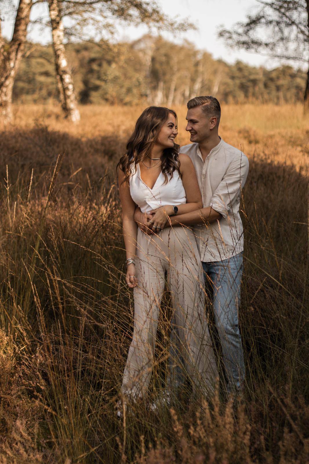 Koppel fotografie Haaksbergen - jong stel in gouden grasveld door Kim Scharenborg Fotografie