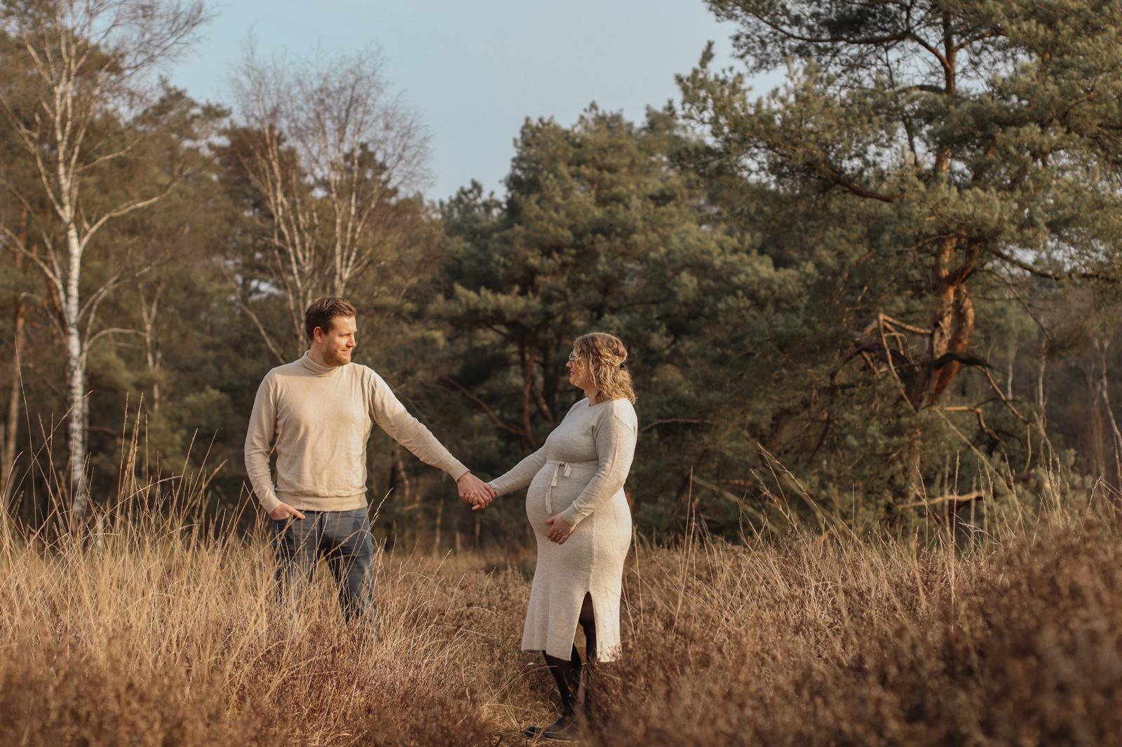 Zwangerschap fotografie Haaksbergen - koppel hand in hand in gouden veld door Kim Scharenborg Fotografie